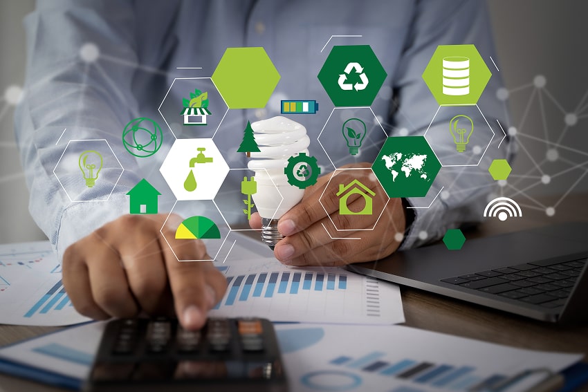 A man doing calculations with sustainability symbols as an overlay to the image