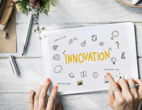A tablet with the word Innovation written on it, as well as different icons and symbols. A tablet with the word Innovation written on it, as well as different icons and symbols.