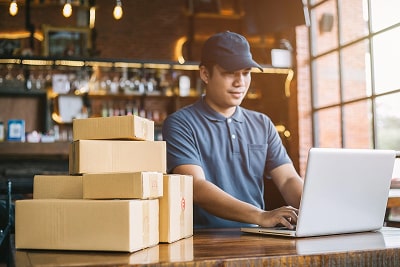 A man working on his laptop with packages beside him