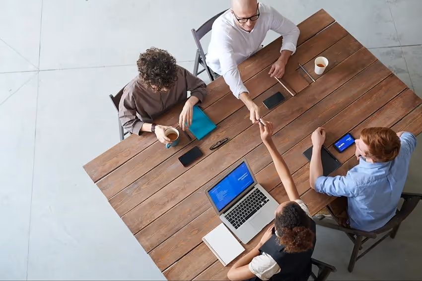 A group of people sitting at a table working together. A group of people sitting at a table working together.