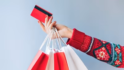 Woman holding card and shopping bags