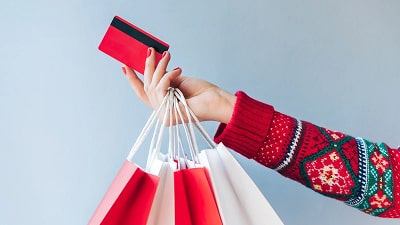 Woman holding card and shopping bags