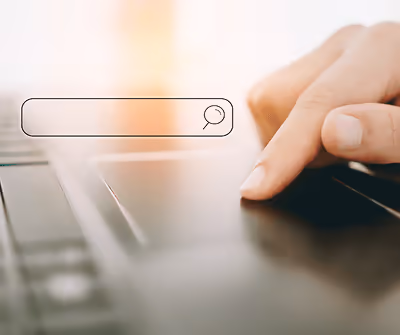 Image of fingers on a touchpad, completing a search on a search engine