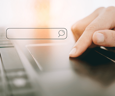 Image of fingers on a touchpad, completing a search on a search engine
