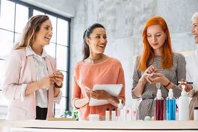 Three women testing and talking about cosmetic products