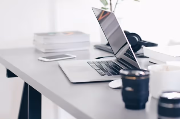 A work desk with equipment such as a laptop A work desk with equipment such as a laptop