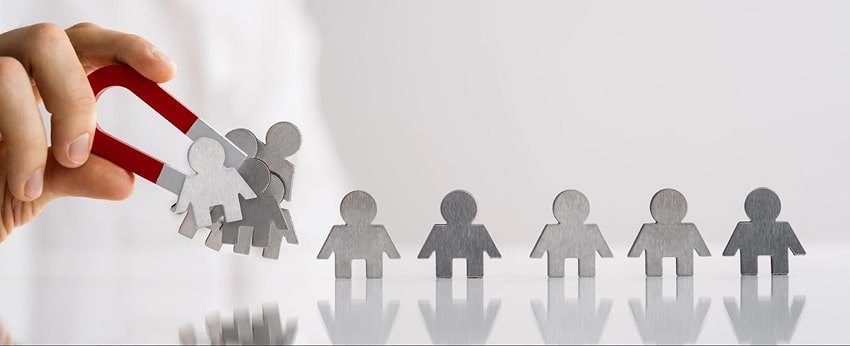 A hand collecting metal figures with a magnet