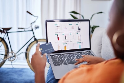 Woman online shopping, holding a laptop and a credit card