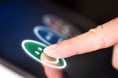 A finger pointing at a display where users can evaluate their experience by clicking on different sm