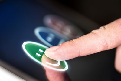 A finger pointing at a display where users can evaluate their experience by clicking on different sm