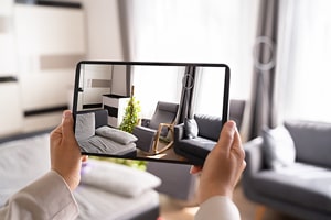 Someone holding a tablet displaying an image of some furniture.