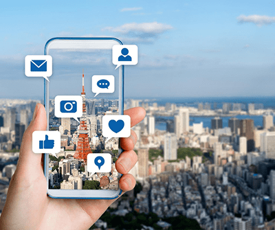 Social media icons on phone with a city in the background