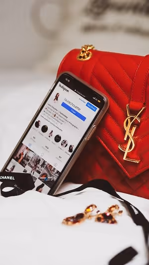 Instagram app open on a phone, next to a purse