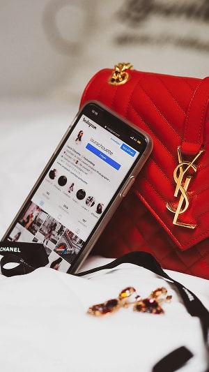 Instagram app open on a phone, next to a purse