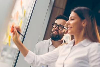 Business people planning strategy writing on post-its Business people planning strategy writing on post-its