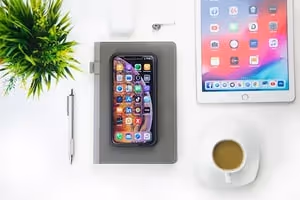 A work desk with a phone and tablet