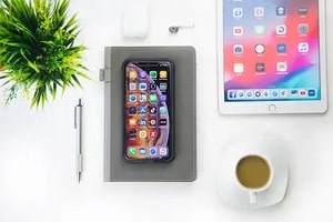A work desk with a phone and tablet