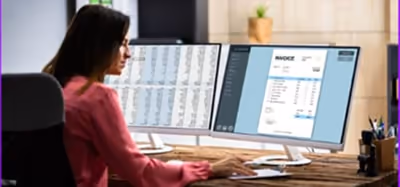 A woman using an accounting software on her monitor screen. A woman using an accounting software on her monitor screen.