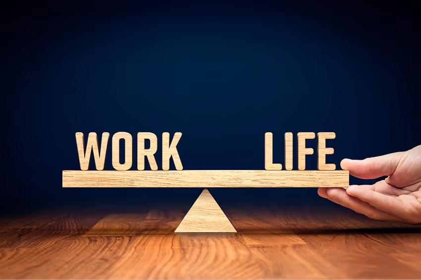 The words work and life balancing on a wooden scale The words work and life balancing on a wooden scale