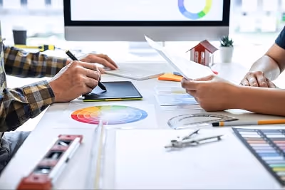 People drawing on a tablet, colour wheels and drawing tools and on a table People drawing on a tablet, colour wheels and drawing tools and on a table