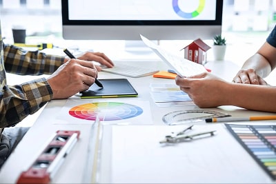 People drawing on a tablet, colour wheels and drawing tools and on a table 
