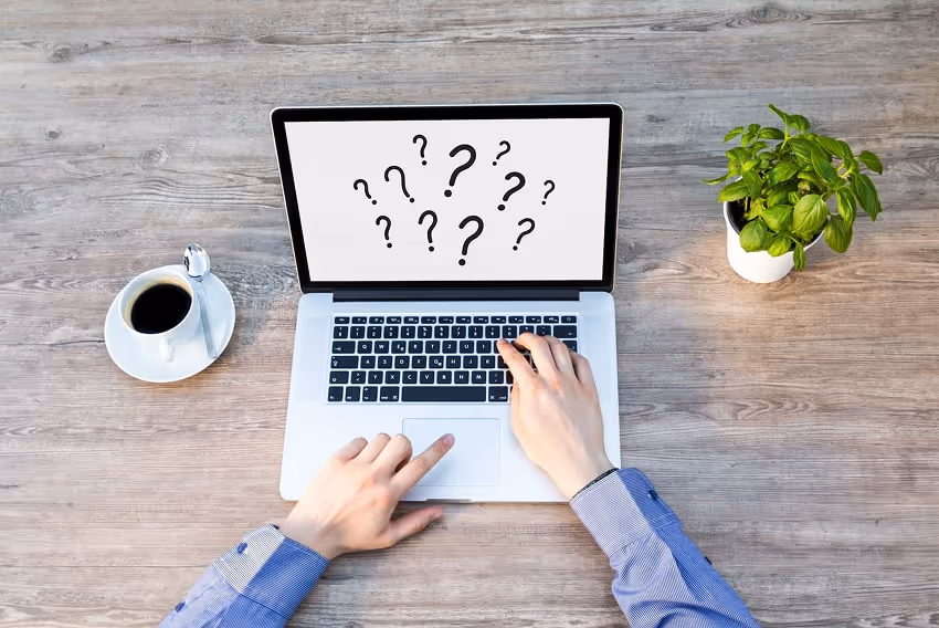 A laptop screen showing lots of question marks that refer to the question of what interactive conten A laptop screen showing lots of question marks that refer to the question of what interactive conten