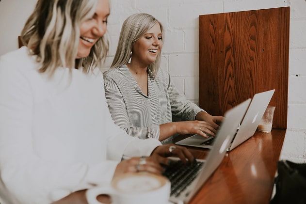 Two women working on their laptops